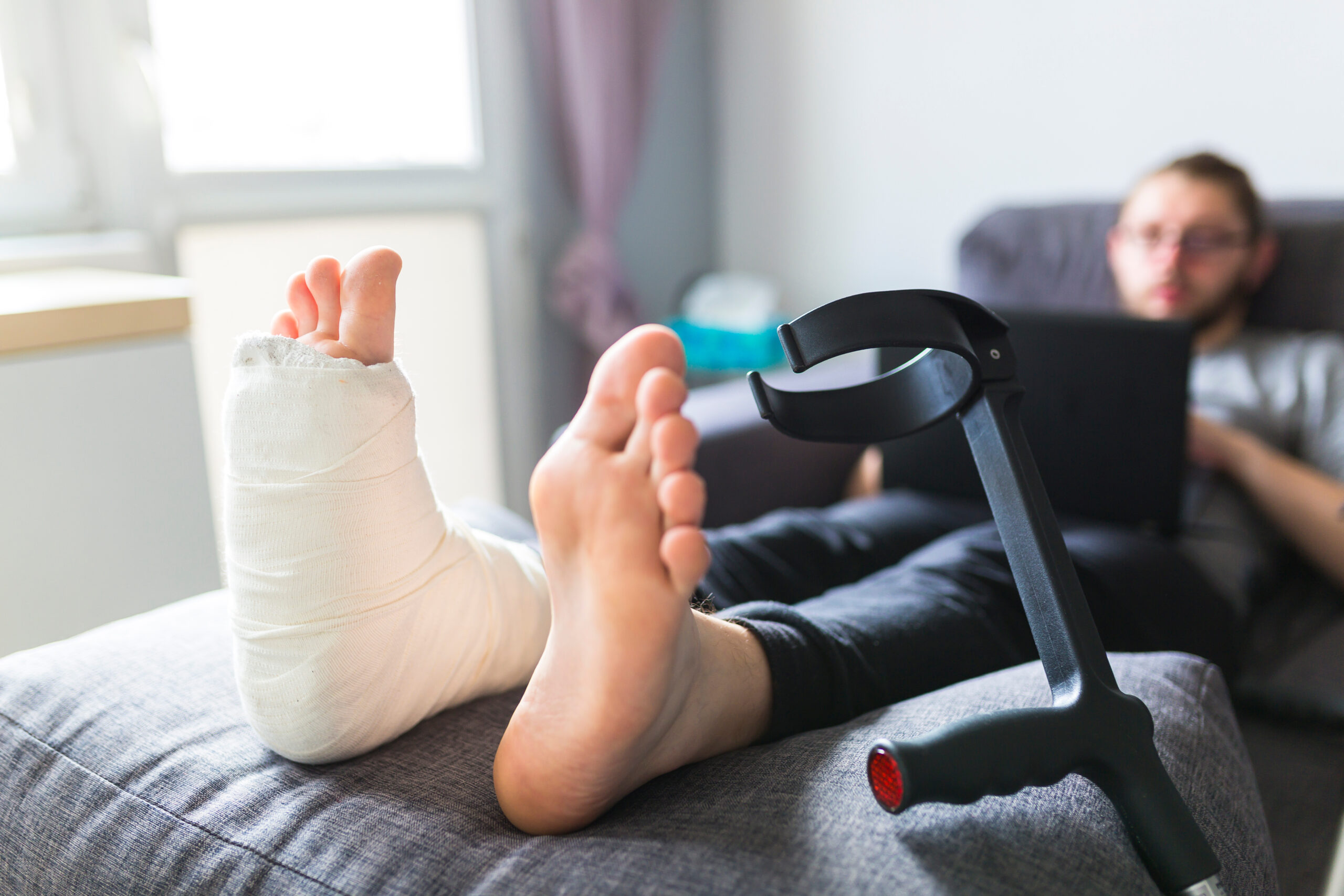 Boy with crutches and broken leg at home