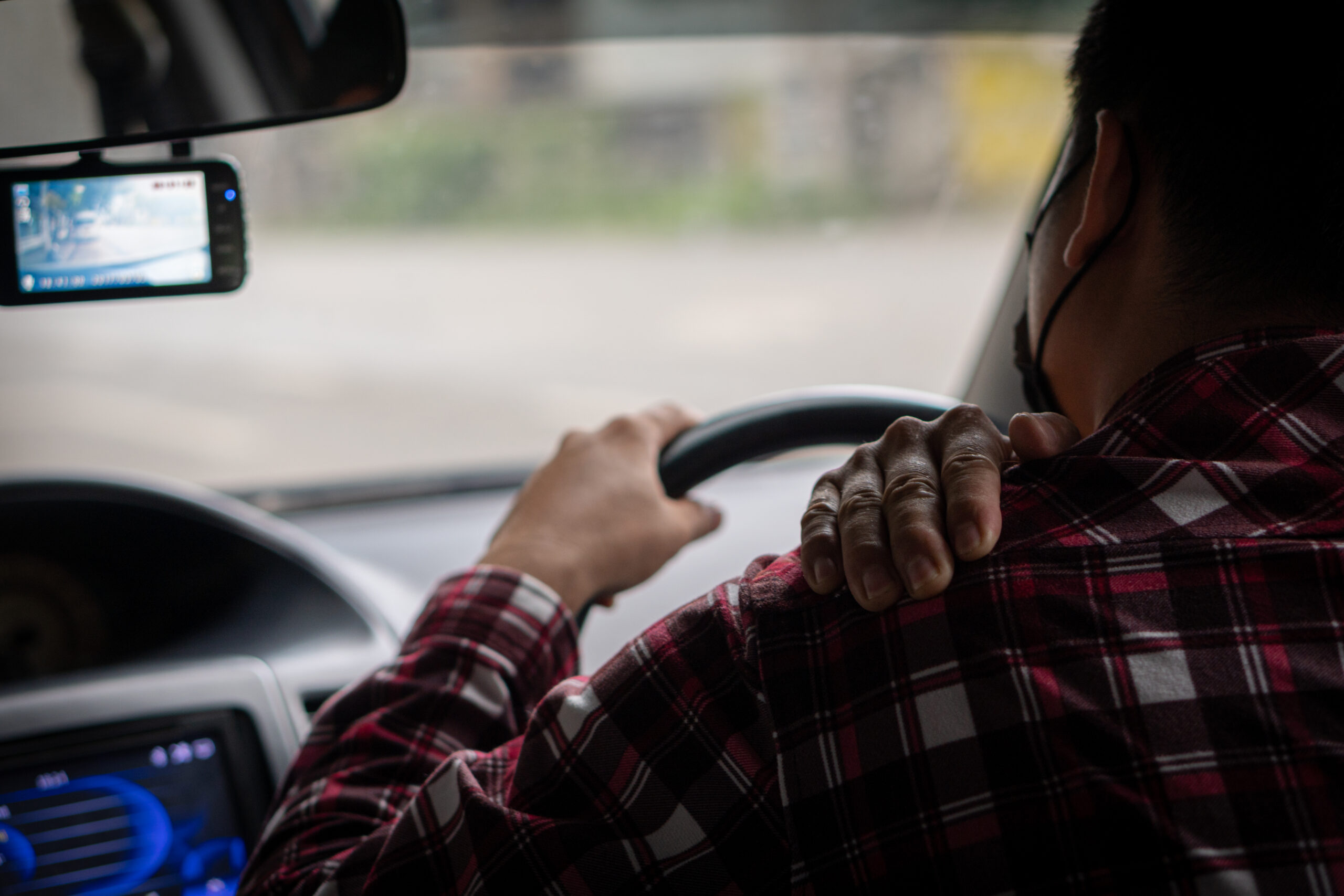 The young man had shoulder pain that was driving a long-distance car and gently massaged his right.