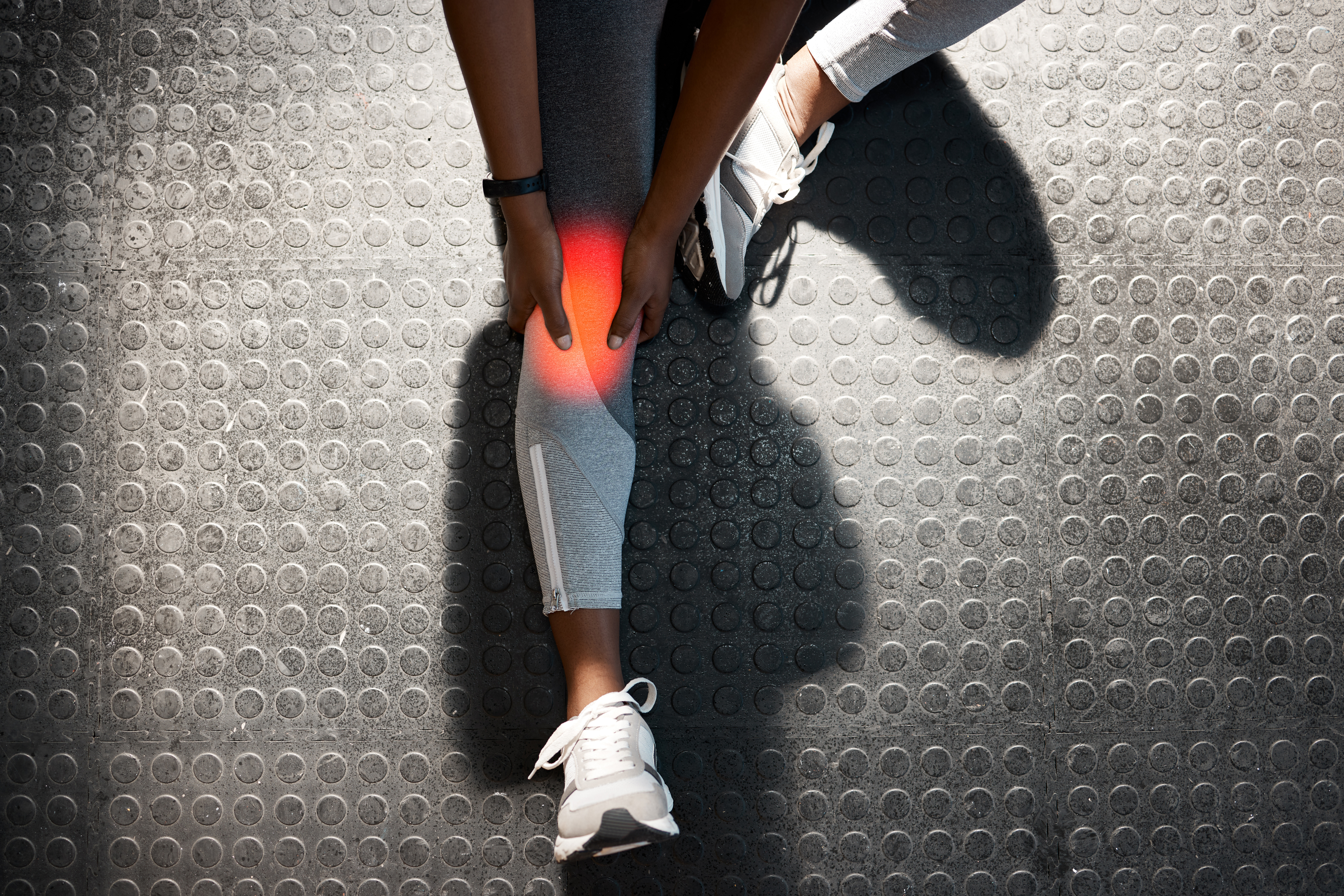 Gym, hands or person with knee injury, accident or pain in exercise or fitness emergency on floor. Sports training, red glow or above of athlete with bruise or sprain leg muscle or bone in workout